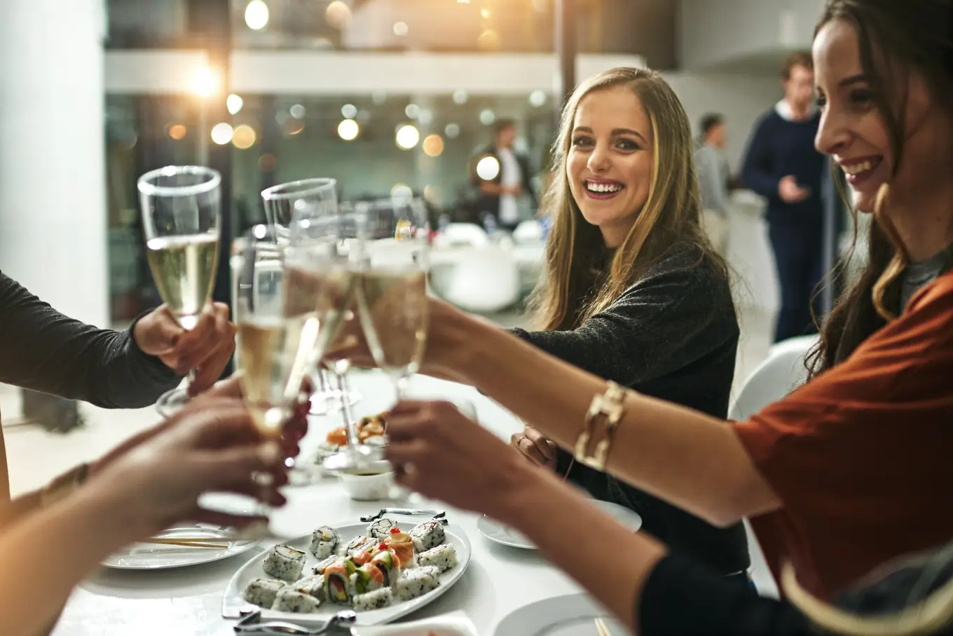 goście w restauracji stukają się kieliszkami